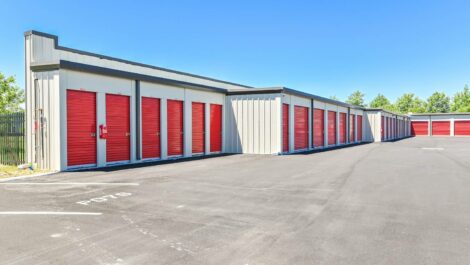 Front view of a modern self-storage facility with clean, red outdoor storage units.