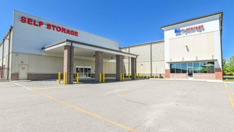 Landscape view of a self-storage facility with a well-and a bright blue sky.