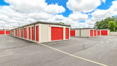 Wide-angle view of a self-storage facility with multiple storage units, clean surroundings, and a bright, clear sky.