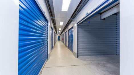 Wide view of a self-storage facility with a variety of storage unit sizes, a clean driveway, and well-maintained grounds.