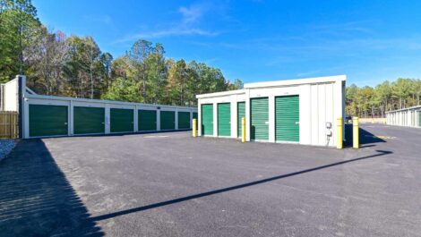 Front view of a self-storage facility at sunset, showcasing the main entrance with a sign and well-lit surroundings.