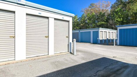 Wide-angle view of a self-storage facility with multiple units, clean surroundings, and a bright, clear sky.