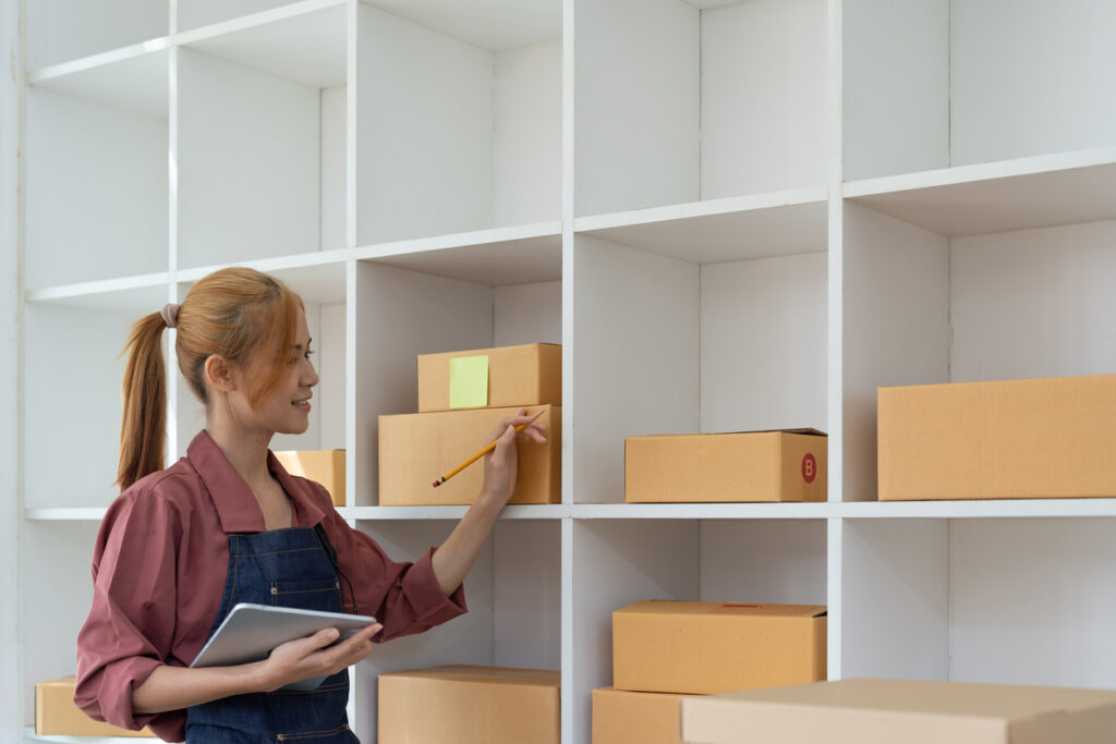 A young woman with a tablet takes stock of her inventory to prepare for storage