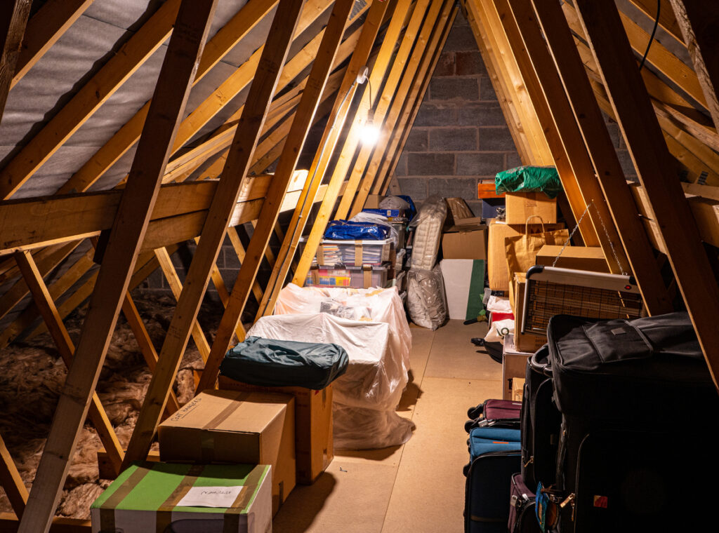 Several boxes of items are packed inside an attic.