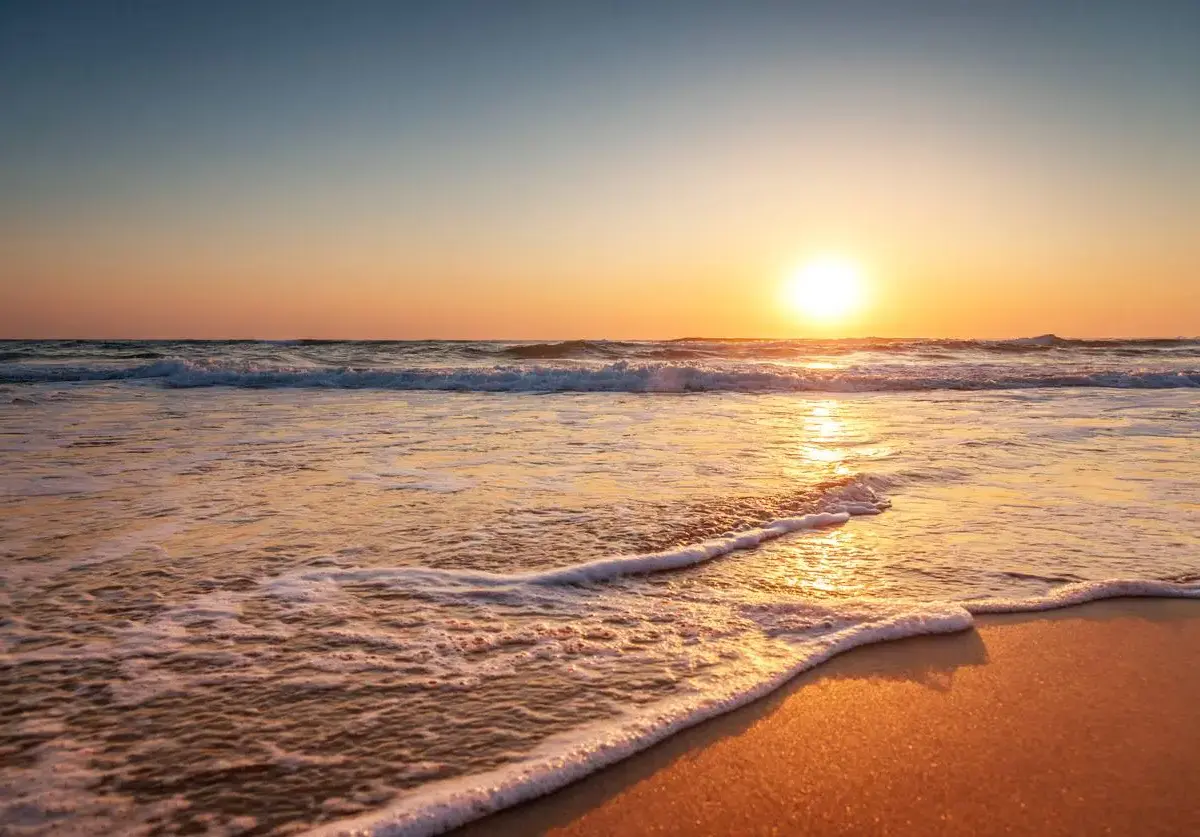The sun rising over a calm beach in Virginia.