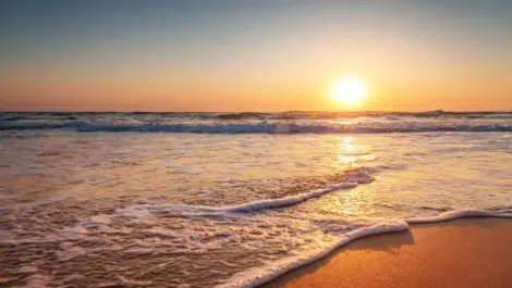The sun rising over a calm beach in Virginia.